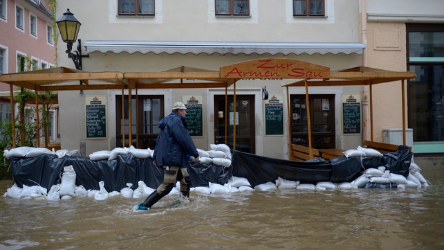 A man walks past a restaurant surrounded by the floods of the river Elbe in Pirna, eastern Germany
