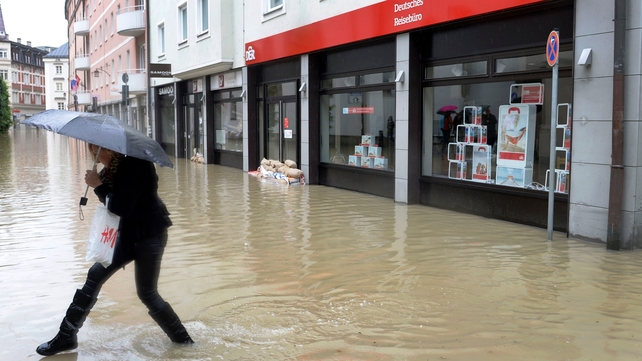 A woman makes her way through an overflooded street in Passau, southern Germany