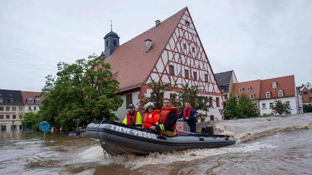 Firefighters and helpers evacuate inhabitants in the flooded city centre in Grimma, Germany.