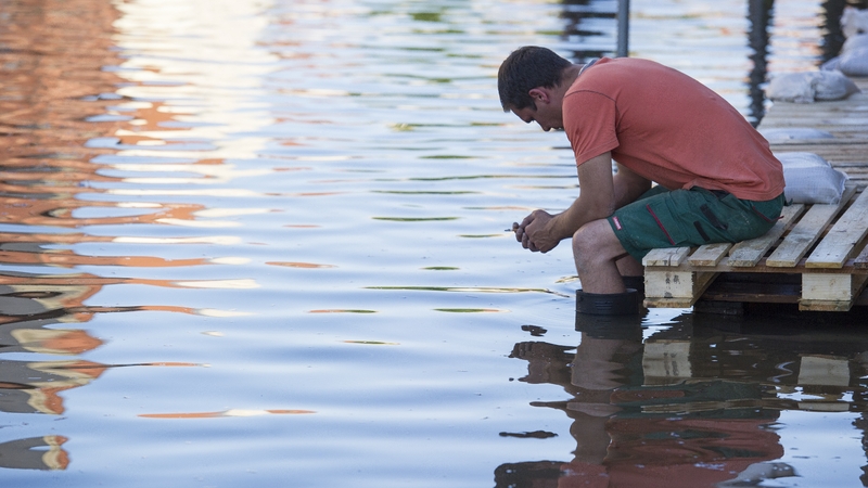 A helper sitting on a provisional footbridge in the flooded city centre in Bernburg, Germany