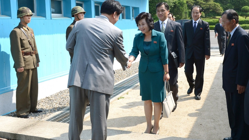 South Korea's delegate (L) shakes hands with North Korea's head of working-level delegation Kim Song-Hye (R) as she crosses the military demarcation line for the meeting at Pammunjon