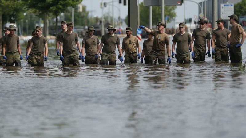 Soldiers of the German Bundeswehr walk through flood waters from the swollen Elbe river
