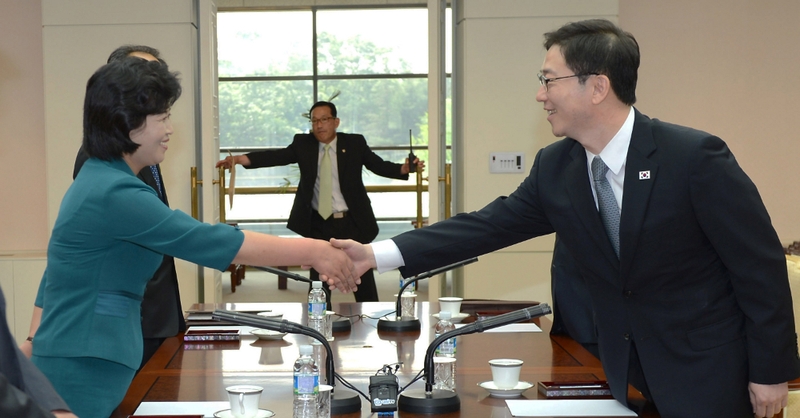 South Korea's senior Unification Ministry official and head of working-level delegation Chun Hae-Sung (R) shakes hands with his North Korean counterpart Kim Song-Hye (L)