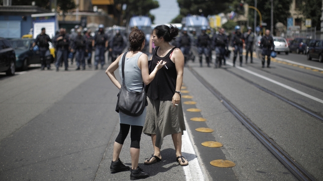 Students look on as police block a street in Rome on the eve of the 2009 summit in Italy