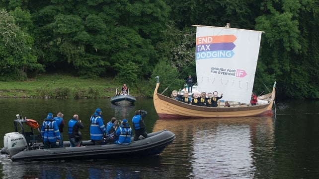 Photographers (L) take pictures of demonstrators from the 'IF campaign' wearing masks depicting G8 leaders