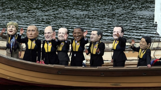 Protesters wearing masks of the G8 Leaders stand in a boat on Lough Erne during the first day of the G8 Summit