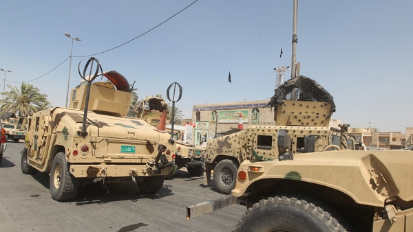 Iraqi military vehicles are stationed in front of the Shia Muslim mosque in Baghdad