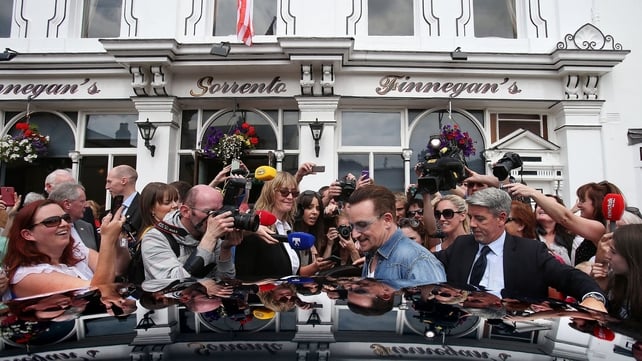 Bono is mobbed by fans (and a few journalists) as he leaves the pub in Dalkey