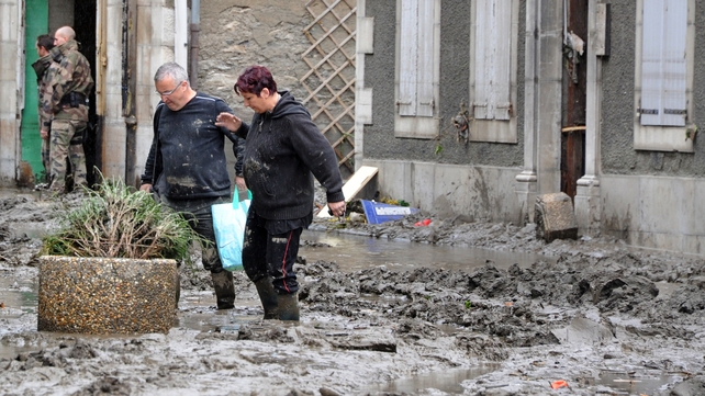 Villagers make their way through the mud-caked streets of Saint-Beat