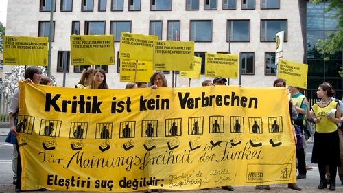 Protesters from Amnesty International gather outside Turkey's embassy in Berlin urging Turkey to respect the right to demonstrate
