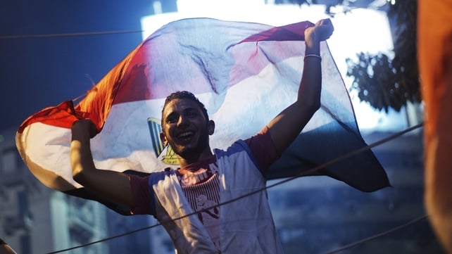 People celebrate after confirmation that the army will be taking over