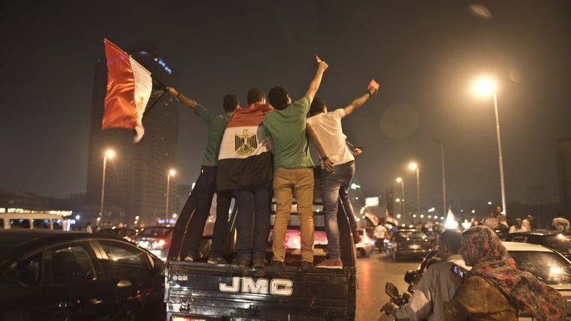 Egyptian youths on a police vehicle celebrate in Cairo