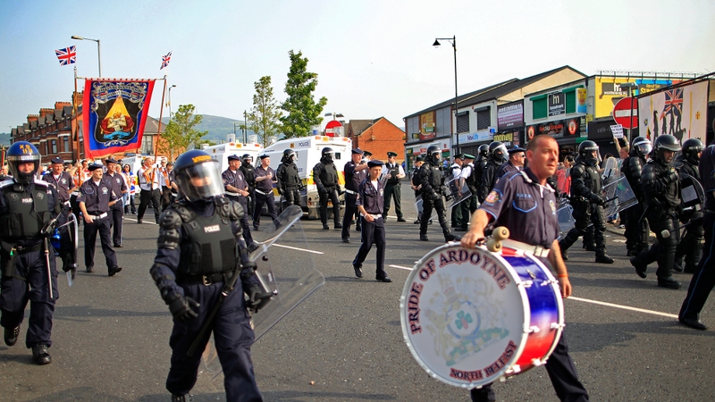 PSNI officers escort an Orange feeder parade on the Crumlin Road in Belfast