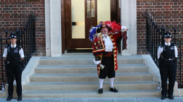 A town crier stands outside the hospital to announce the birth of a baby boy