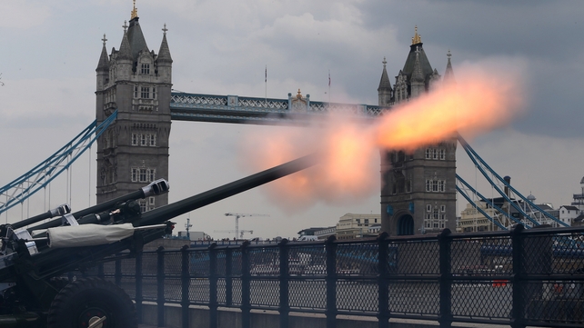 Guns fire outside the Tower of London as part of a salute to the royal baby