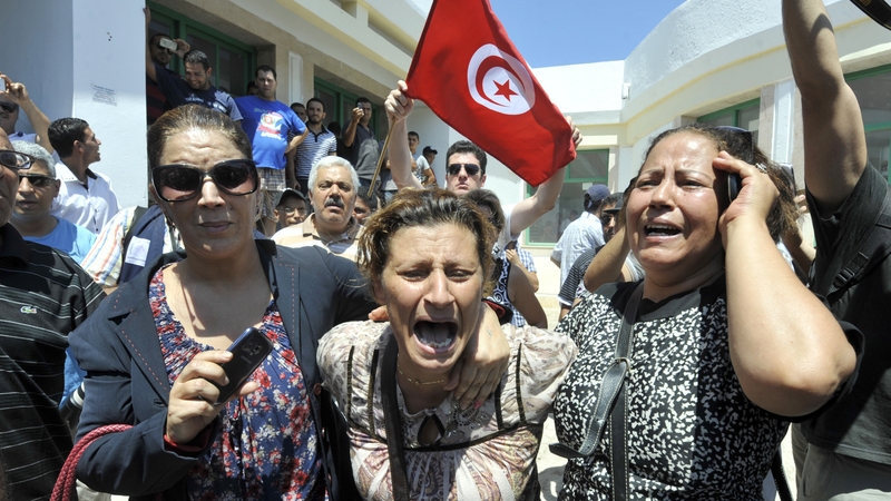Tunisians react outside a hospital after the killing of Mohamed Brahmi