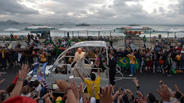 Pope Francis waves from the popemobile as he arrives at Copacabana beach to participate in a re-enactment of the Stations of the Cross