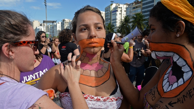 Young women prepare to take part in a protest against the Catholic Church