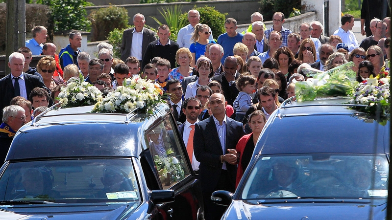Eoghan and Ruairi's mother Kathleen (C) walks behind her sons' coffins