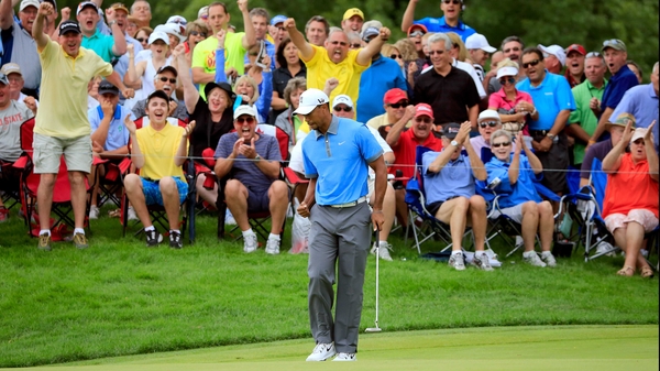 Tiger Woods makes a birdie putt on the 12th