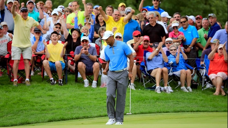Tiger Woods makes a birdie putt on the 12th