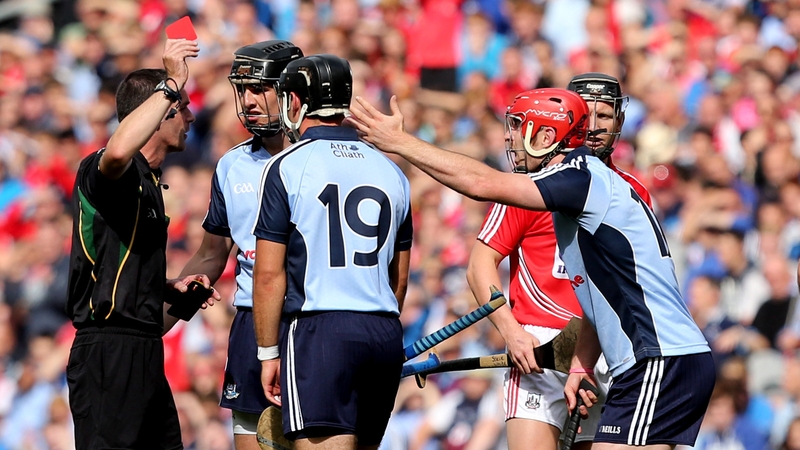 Referee James Owen brandishes a red card to Ryan O'Dwyer