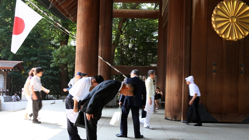 Japanese men bow at the Yasukuni Shrine in Tokyo
