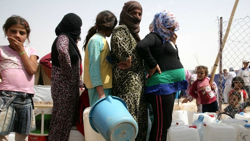 Syrian refugees queue for water at the Domiz refugee camp in northern Iraq