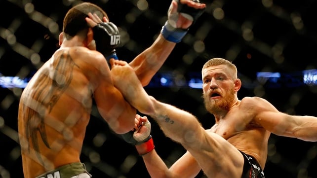 Conor McGregor kicks Max Holloway in their UFC bout in Boston, Massachusetts