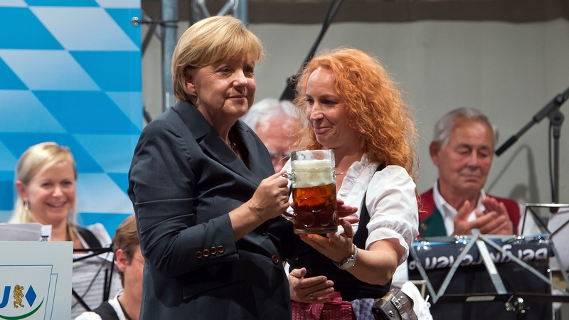 German chancellor Angela Merkel holds a beer after speaking in a beerfest tent while campaigning for upcoming federal elections