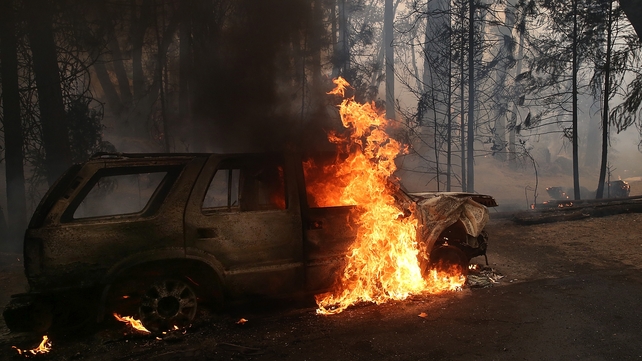 A car continues to burn after being consumed by the blaze