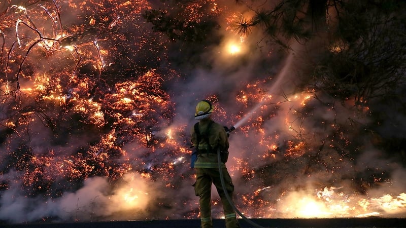 A fire fighter douses the flames as the fire rages on the edge of Yosemite National Park