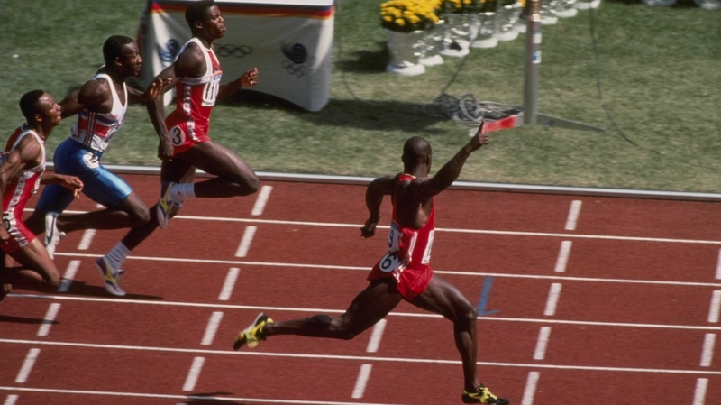 Ben Johnson (l) raises his arm as he finishes first in the 100m at the 1988 Olympics