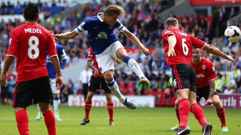 Nikica Jelavic of Everton heads the ball past Ben Turner of Cardiff