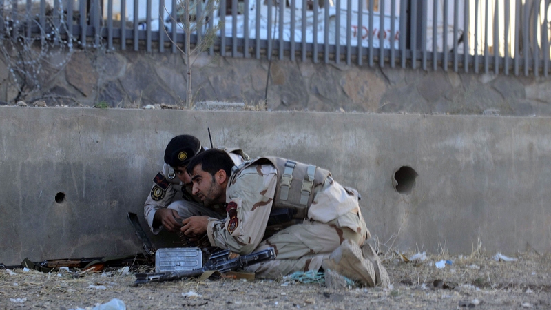 Security forces take cover during the attack in Herat