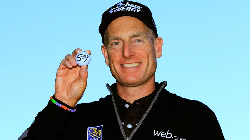 Jim Furyk holds up his ball with a '59' on it after shooting a 12 under round of 59