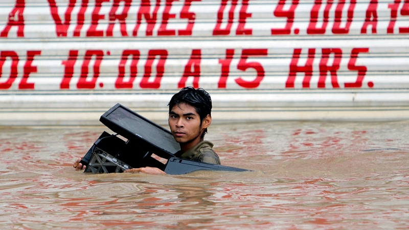 Residents waded neck-deep in brown muddy waters
