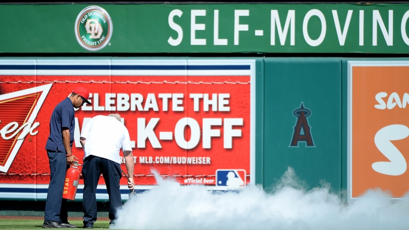 Ground staff attempt to remove bees that delayed the game at Angel Stadium