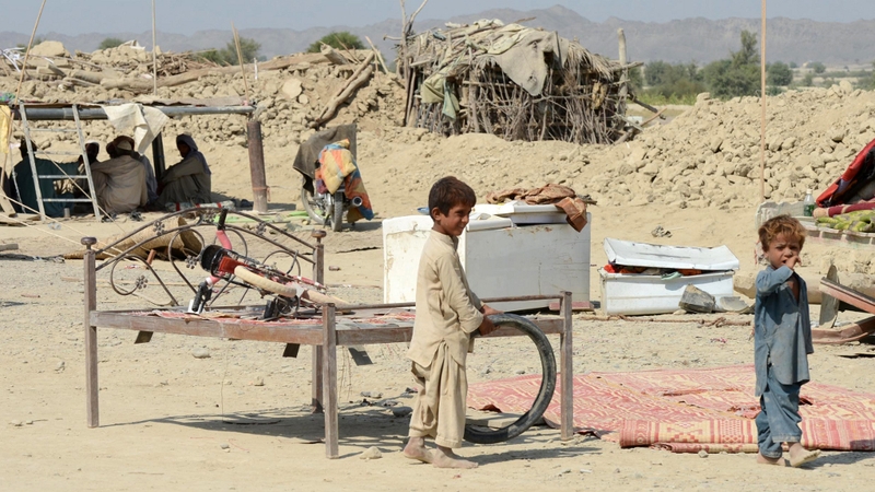 Children play near collapsed mud houses following the earthquake