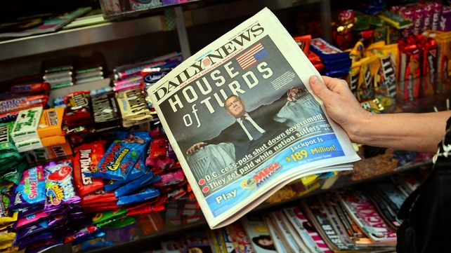 A woman buys a copy of the Daily News, depicting Republican House Speaker John Boehner