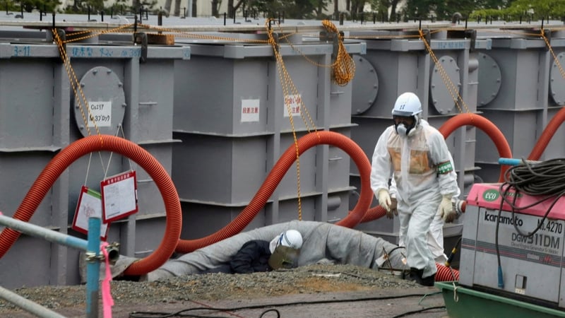 Workers examining waste water tanks at the Fukushima plant in June