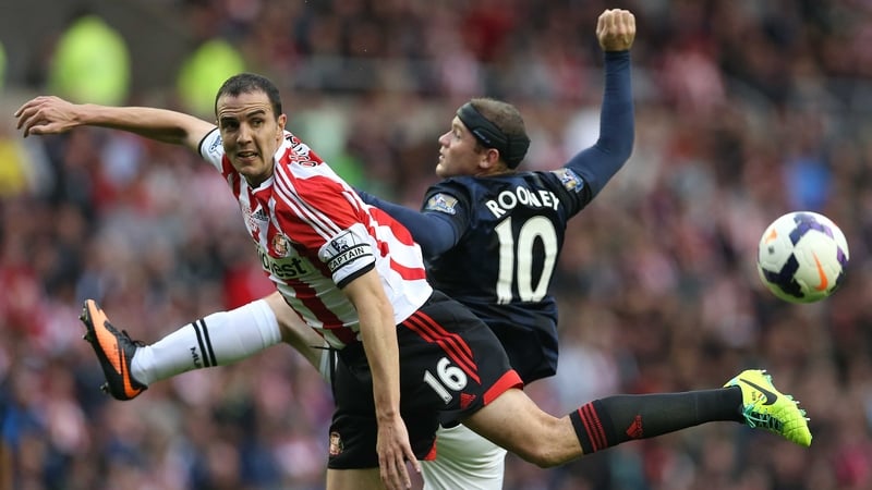 John O'Shea and Wayne Rooney vie for posession