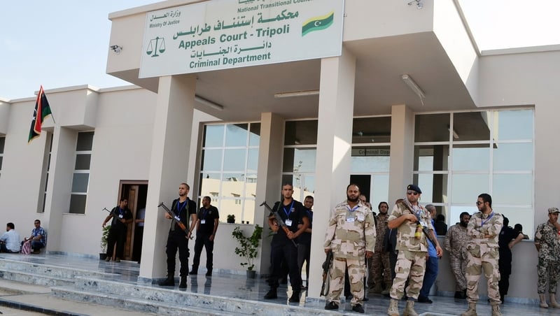 Security forces stand guard outside the Appeals court in Tripoli during a court appearance by ex-intelligence chief Abdullah al-Senussi last month