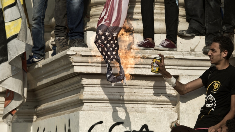 Mohammed Mursi supporters burn the American flag during a rally outside the presidential palace in Cairo