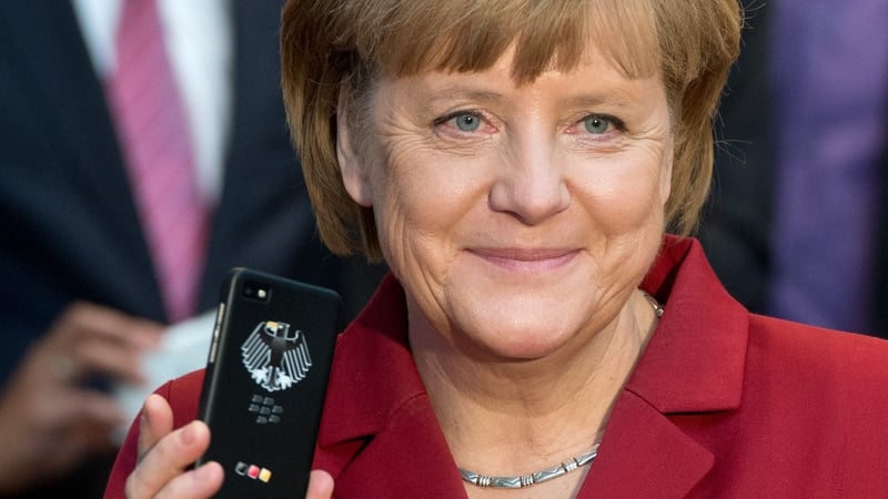 German Chancellor Angela Merkel holding a tapping proof BlackBerry mobile device in March of this year