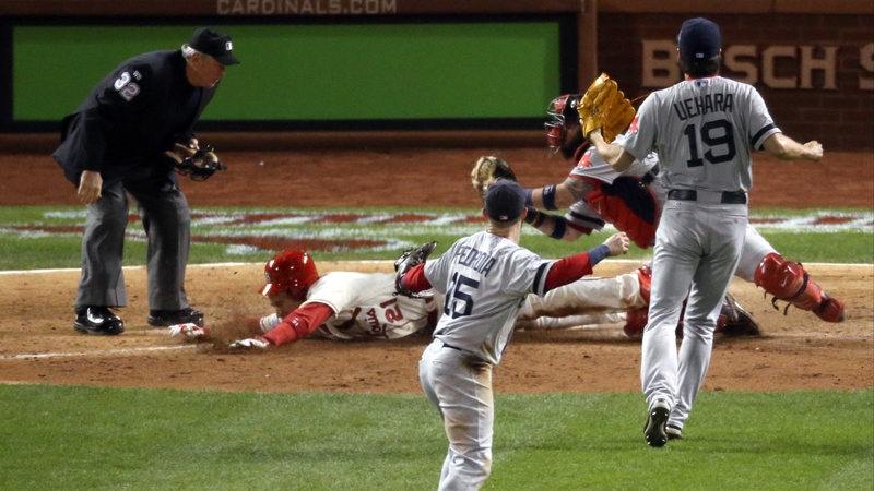 Home plate umpire Dana DeMuth calls Allen Craig of the St. Louis Cardinals safe at home