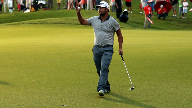 Co-leader Gary Woodland pars the 18th in Kuala Lumpur to finish on 14 under