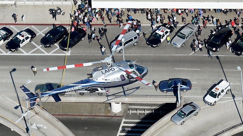 A police helicopter flies over the airport