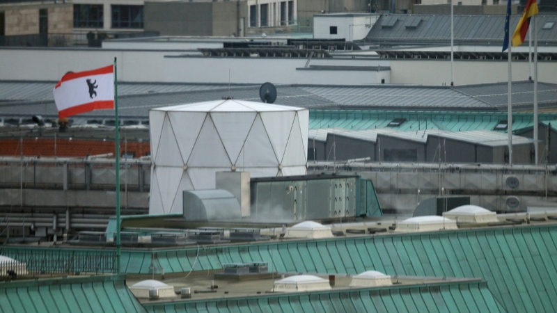 The Berlin flag flies next to a white structure that, according to media reports, contains sophisticated electronic surveillance equipment and stands on top of the British embassy