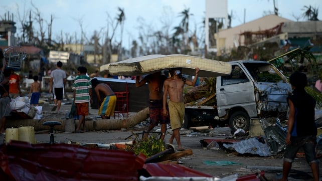 Residents carry a mattres taken from a hotel in Palo, eastern island of Leyte province